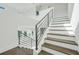 Modern staircase features wood and white steps with a contemporary metal railing at 3024 Kensington Ave, Davenport, FL 33837