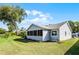 Spacious backyard showing the rear side of the home, with lawn and some trees at 32537 Oak Park Dr, Leesburg, FL 34748