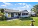 Lush green backyard with bird bath, mature trees, patio area, and partially screened lanai at 32537 Oak Park Dr, Leesburg, FL 34748