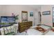 Bedroom featuring traditional wood dresser, framed artwork, TV, and matching comforter at 32537 Oak Park Dr, Leesburg, FL 34748