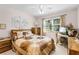 Comfortable bedroom with a large window, wooden furniture, and a ceiling fan at 32537 Oak Park Dr, Leesburg, FL 34748