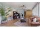 Bright sunroom with wood laminate flooring, ceiling fan and casual furniture; plant and area rug at 32537 Oak Park Dr, Leesburg, FL 34748