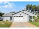 Charming single-story home featuring a well-maintained lawn, attached two-car garage and light-blue siding at 32537 Oak Park Dr, Leesburg, FL 34748