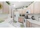 Kitchen features white cabinets, appliances, and tile flooring with foliage accents at 32537 Oak Park Dr, Leesburg, FL 34748