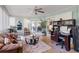 Inviting sunroom with comfortable seating, desk area, ceiling fan, and sun-filled windows at 32537 Oak Park Dr, Leesburg, FL 34748