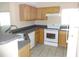 Functional kitchen with wood cabinetry, a new range, and a stainless steel sink under natural light at 3364 Westchester Square Blvd # 204, Orlando, FL 32835