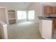 Open living area with built in desk/shelving, neutral carpet, and breakfast bar to the kitchen area at 3364 Westchester Square Blvd # 204, Orlando, FL 32835
