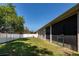 Backyard featuring a white fence, lush green lawn, and an enclosed lanai at 3436 Herringridge Dr, Orlando, FL 32812