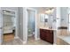 Bathroom with a dark wood vanity and a doorway that leads to the primary bedroom suite at 3436 Herringridge Dr, Orlando, FL 32812