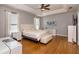 Bright bedroom with tray ceiling, hardwood floors, and ensuite bathroom at 3436 Herringridge Dr, Orlando, FL 32812