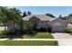 Charming home with stone accents, arched windows, and well-manicured lawn at 3436 Herringridge Dr, Orlando, FL 32812
