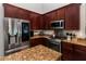 A modern kitchen with stainless steel appliances, dark wood cabinets, and granite countertops at 3436 Herringridge Dr, Orlando, FL 32812