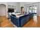 Inviting living room featuring a large blue sectional sofa, built-in shelving, and sliding glass doors at 3436 Herringridge Dr, Orlando, FL 32812