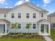 Charming two-story townhome featuring a well-maintained lawn and decorative landscaping at 4216 Sadler Rd, Apopka, FL 32712