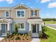 Inviting two-story townhome with stone accents, landscaped yard, and covered porch at 4216 Sadler Rd, Apopka, FL 32712