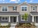 Charming townhouse featuring a well-manicured lawn and inviting front entrance with decorative stone pillar accents at 4236 Sadler Rd, Apopka, FL 32712