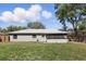 The backyard of the home featuring a well-maintained lawn and a screened porch at 5163 Lighthouse Rd, Orlando, FL 32808