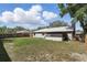 A view of the backyard, showcasing the lush green lawn, screened porch, and privacy fence at 5163 Lighthouse Rd, Orlando, FL 32808
