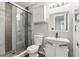 Bathroom featuring a tiled shower with a glass door, modern sink, toilet, and storage at 5163 Lighthouse Rd, Orlando, FL 32808