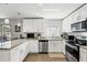 Bright kitchen featuring white cabinetry, stainless steel appliances, and stone countertops at 5163 Lighthouse Rd, Orlando, FL 32808