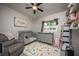 Bedroom with modern furnishings, including a crib and dresser, featuring a ceiling fan for added comfort at 605 Oranole Rd, Maitland, FL 32751