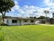 Landscaped front yard with a well maintained lawn, carport and mature trees at 605 Oranole Rd, Maitland, FL 32751