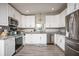 Bright kitchen with stainless steel appliances, granite counters, and white cabinetry at 605 Oranole Rd, Maitland, FL 32751