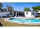 Backyard pool with screened in porch, barbecue grill, white home exterior, and blue skies at 605 Oranole Rd, Maitland, FL 32751