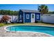 Pool area surrounded by pavers with a blue shed, small palm trees and outdoor seating at 605 Oranole Rd, Maitland, FL 32751