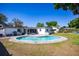 Wide shot of the backyard pool with a screened in porch and white home exterior under clear blue skies at 605 Oranole Rd, Maitland, FL 32751