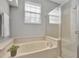 Bathroom featuring a tiled soaking tub with a shower and glass door at 7021 Della Dr # 52, Orlando, FL 32819