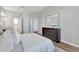 Well-lit bedroom boasts wood floors, white bedding, a decorative rug, and a view into the attached bathroom at 7021 Della Dr # 52, Orlando, FL 32819