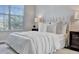 Bright bedroom featuring a large window, white walls, and tufted headboard at 7021 Della Dr # 52, Orlando, FL 32819