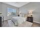 Bright bedroom featuring a plush bed with white bedding, complemented by wood floors and a sunny window at 7021 Della Dr # 52, Orlando, FL 32819