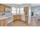 Well-lit kitchen with wooden cabinetry, white appliances, and a breakfast nook at 7021 Della Dr # 52, Orlando, FL 32819