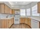 Well-lit kitchen with light wood cabinets, white appliances, and modern countertops at 7021 Della Dr # 52, Orlando, FL 32819