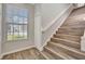Well-lit staircase with wood-look steps and a window, creating an open feel at 7021 Della Dr # 52, Orlando, FL 32819