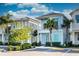 Charming light blue two-story home with a balcony and tropical landscaping under a blue sky at 8044 Dreamsicle Dr, Kissimmee, FL 34747