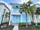 Charming two-story coastal home featuring a front porch, balcony, and lush tropical landscaping at 8044 Dreamsicle Dr, Kissimmee, FL 34747