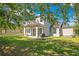 Green backyard featuring a covered patio, a lush lawn, and mature trees at 8555 Abbotsbury Dr, Windermere, FL 34786