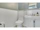 This bathroom features a stylish pedestal sink, a toilet, and bright white tile at 8555 Abbotsbury Dr, Windermere, FL 34786