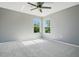 This bedroom offers natural light from two windows and a ceiling fan providing comfort and fresh air at 8555 Abbotsbury Dr, Windermere, FL 34786