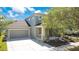 Charming two-story home boasts a manicured lawn, a covered entryway, and attached garage at 8555 Abbotsbury Dr, Windermere, FL 34786