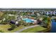 Aerial view of the community pool, clubhouse, and landscaping near a pond in a community at 8565 Tallfield Ave # 1, Orlando, FL 32832