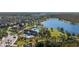 Aerial view of a community center, showcasing a pool and clubhouse amidst trees and nearby houses and a pond at 8565 Tallfield Ave # 1, Orlando, FL 32832