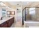 Bathroom featuring double sinks, granite countertops, a glass shower, and neutral tones at 8565 Tallfield Ave # 1, Orlando, FL 32832