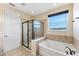 Bathroom features a glass-enclosed shower and a soaking tub with modern fixtures at 8565 Tallfield Ave # 1, Orlando, FL 32832