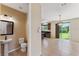 Open-concept kitchen features a convenient half bath, stainless steel appliances, and sliding glass doors to the backyard at 8565 Tallfield Ave # 1, Orlando, FL 32832
