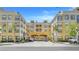 Beautifully landscaped yellow condominium building with palm trees, and breezeway for parking at 860 N Orange Ave # 226, Orlando, FL 32801