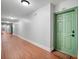 Hallway with wood floors leading to unit 226 with green door and welcome mat at 860 N Orange Ave # 226, Orlando, FL 32801